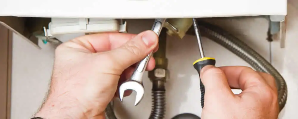 Boiler repair technician tightening pipe fittings and connections in Milwaukee, WI
