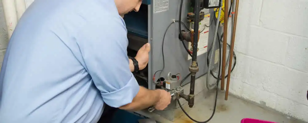 Furnace repair technician inspecting and servicing a home heating system in Milwaukee, WI