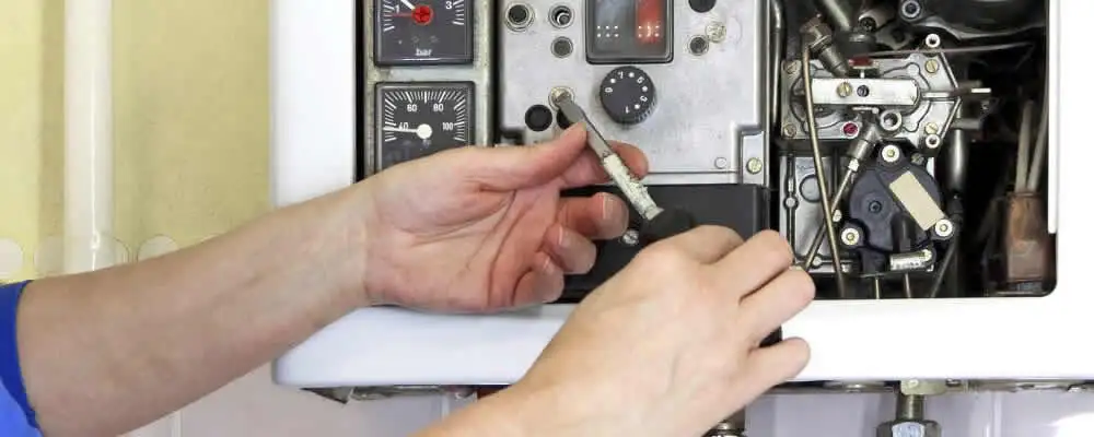 Heating repair technician adjusting boiler controls and components in Milwaukee, WI