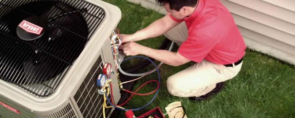 HVAC technician servicing an outdoor air conditioner unit in Milwaukee, WI