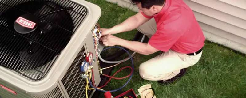 HVAC technician servicing an outdoor air conditioner unit in Milwaukee, WI