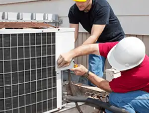 HVAC technicians repairing an outdoor AC unit on a rooftop in Milwaukee, WI