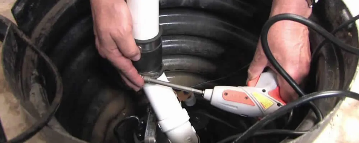 Sump pump installation technician connecting PVC discharge piping in Milwaukee, WI
