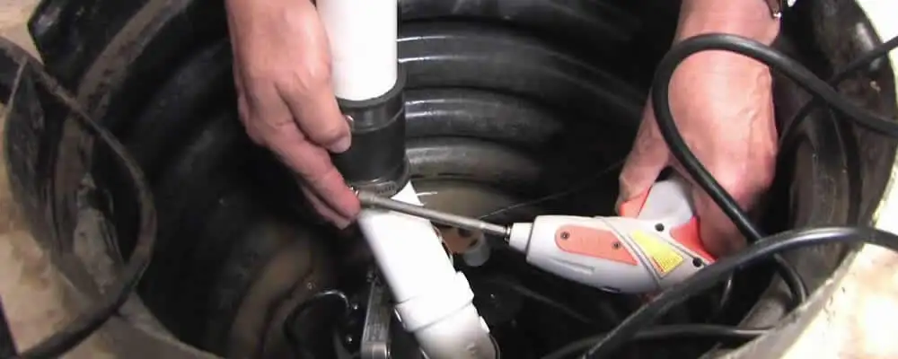 Sump pump installation technician connecting PVC discharge piping in Milwaukee, WI