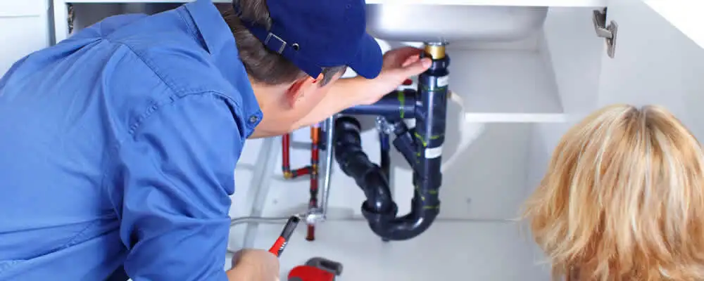 Plumber repairing under-sink drain pipes and fittings in Milwaukee, WI